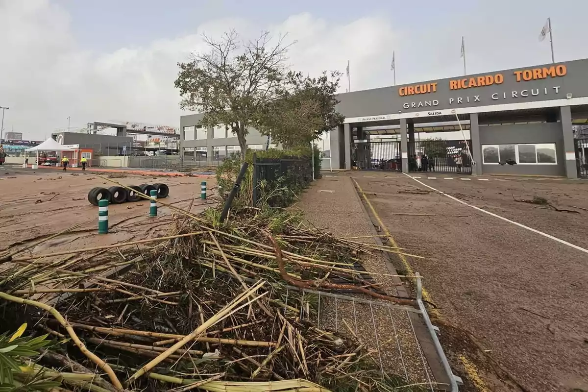 Entrada del Circuito Ricardo Tormo con escombros y ramas en el suelo después de una tormenta.