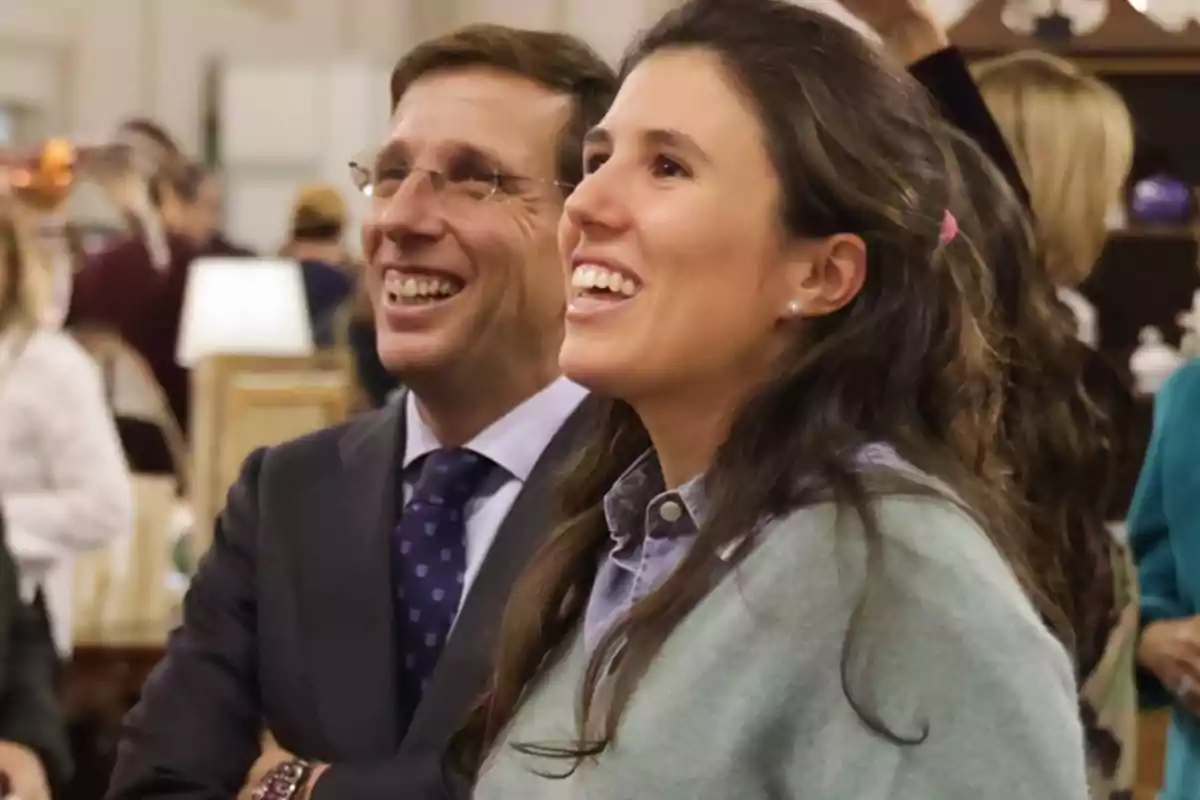 Two smiling people at a social event.