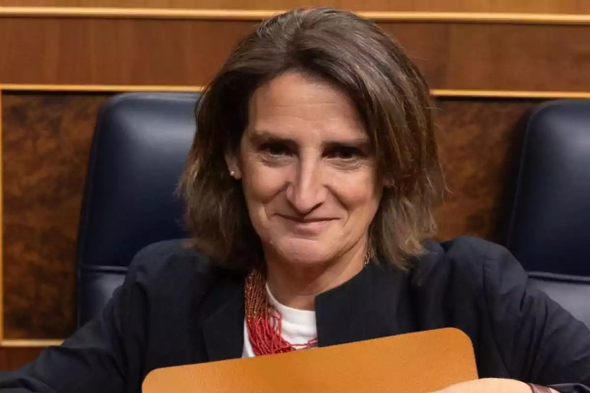 Una persona con cabello castaño y una chaqueta oscura está sentada en una silla de oficina.