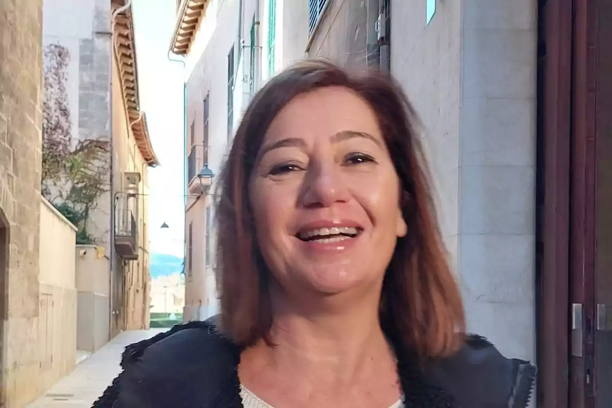 A smiling woman on a narrow street with stone buildings. A smiling woman on a narrow street with stone buildings.