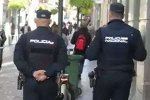 Two police officers walking down a busy street.