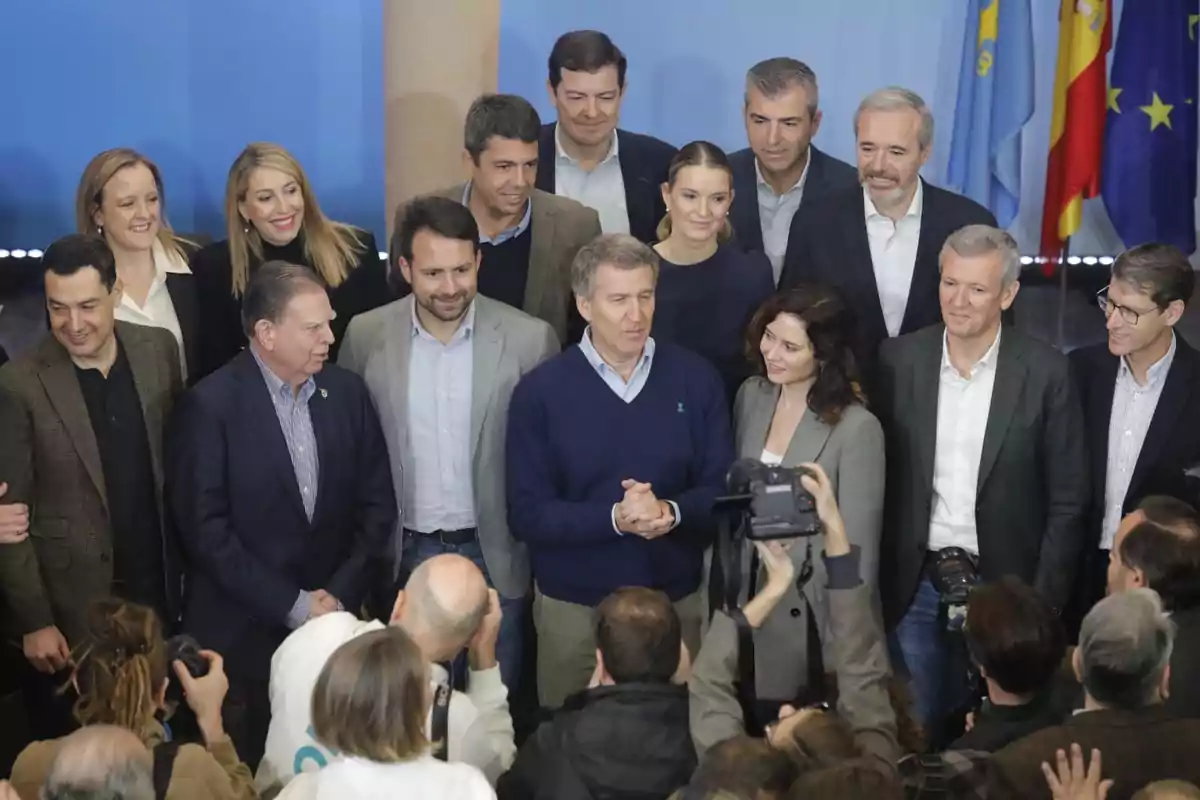 Un grupo de personas posando para una foto frente a varias banderas.