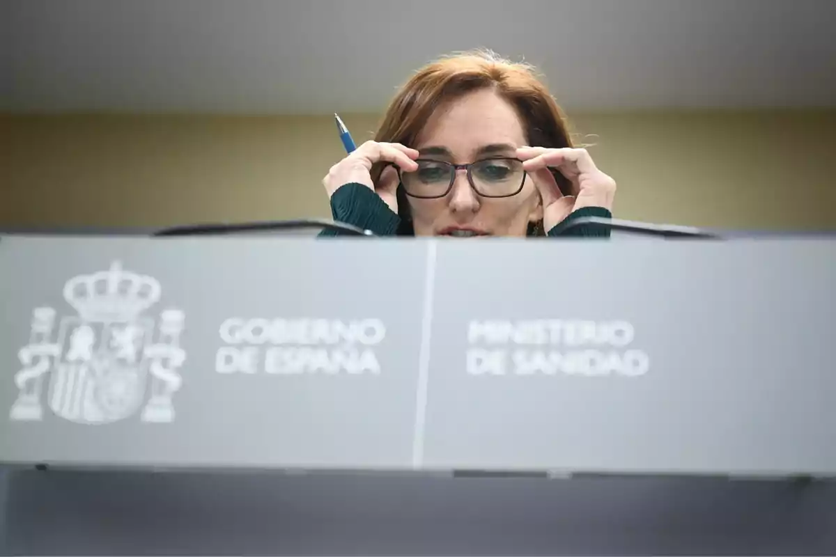 Una persona ajustándose las gafas detrás de un atril del Ministerio de Sanidad del Gobierno de España. Una persona ajustándose las gafas detrás de un atril del Ministerio de Sanidad del Gobierno de España.