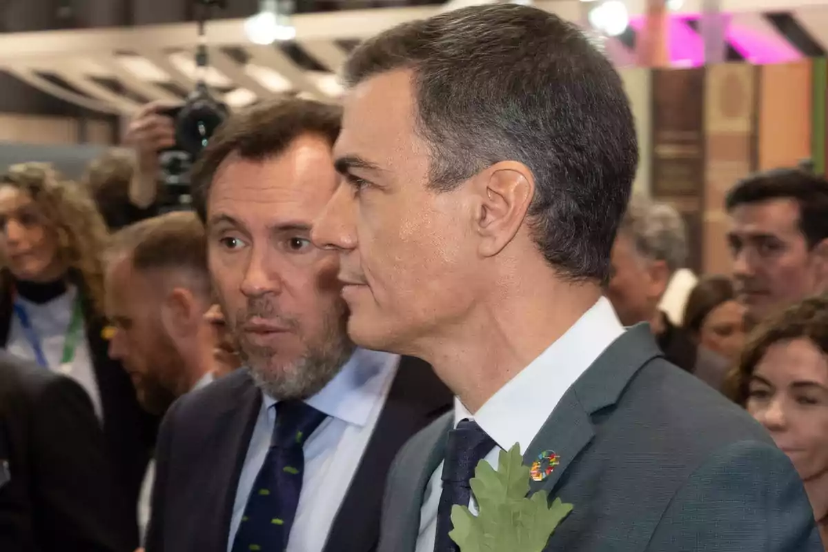 Dos hombres en un evento formal rodeados de otras personas. Dos hombres en un evento formal rodeados de otras personas.