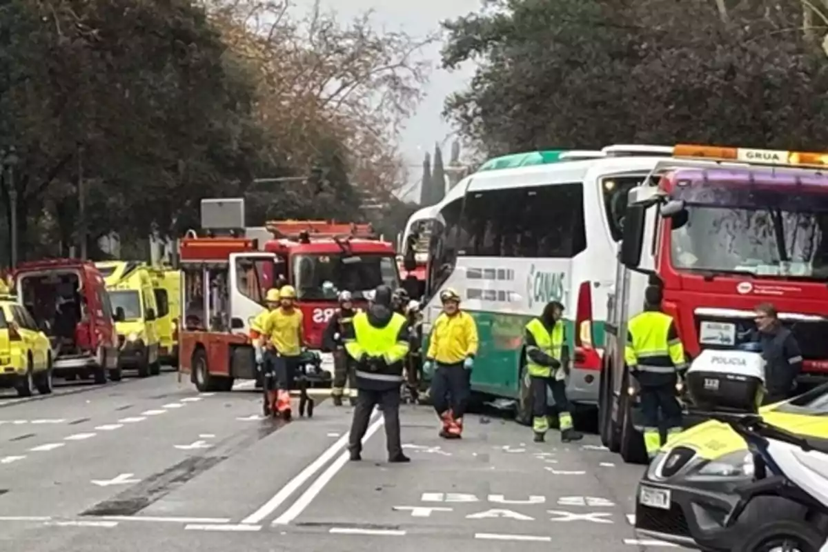 A group of emergency services is working at the scene of a traffic accident on a street, with several emergency vehicles and a bus involved.