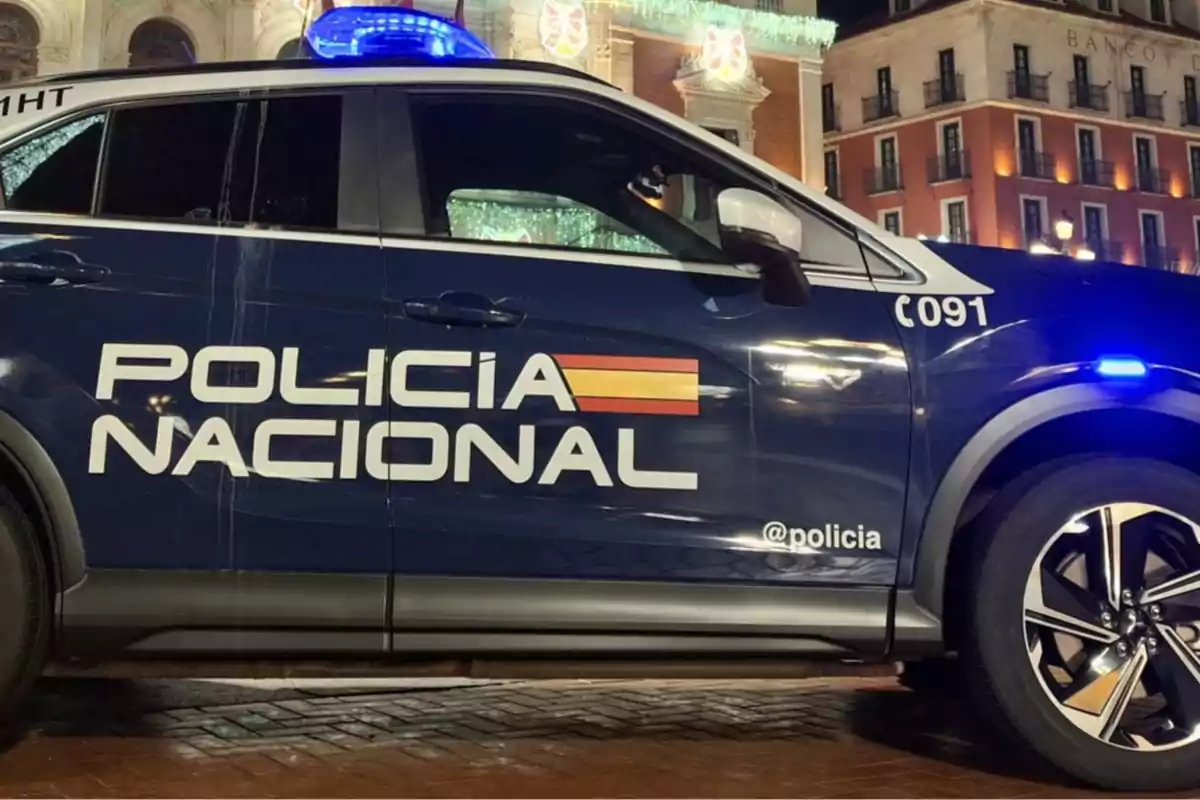 Un coche de la Policía Nacional estacionado en una calle iluminada por la noche.