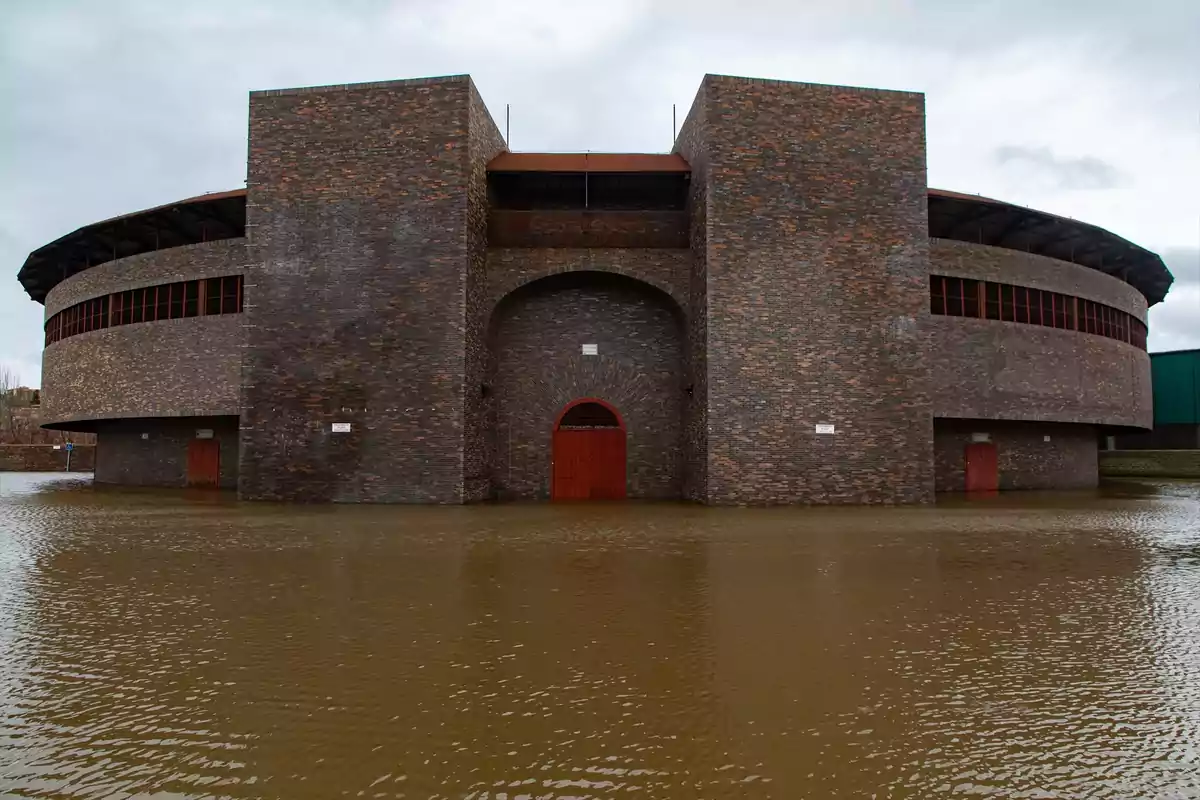 Edificio de ladrillo rodeado de agua debido a una inundación.