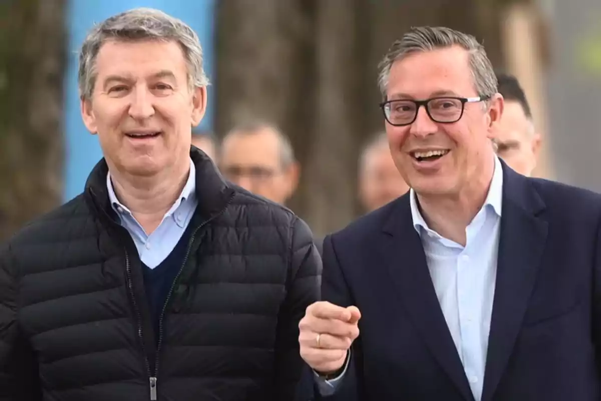 Dos hombres sonrientes caminando al aire libre.