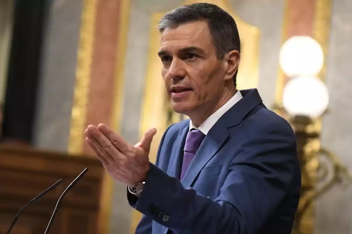 Un hombre en traje azul hablando en un podio en un entorno formal. Un hombre en traje azul hablando en un podio en un entorno formal.