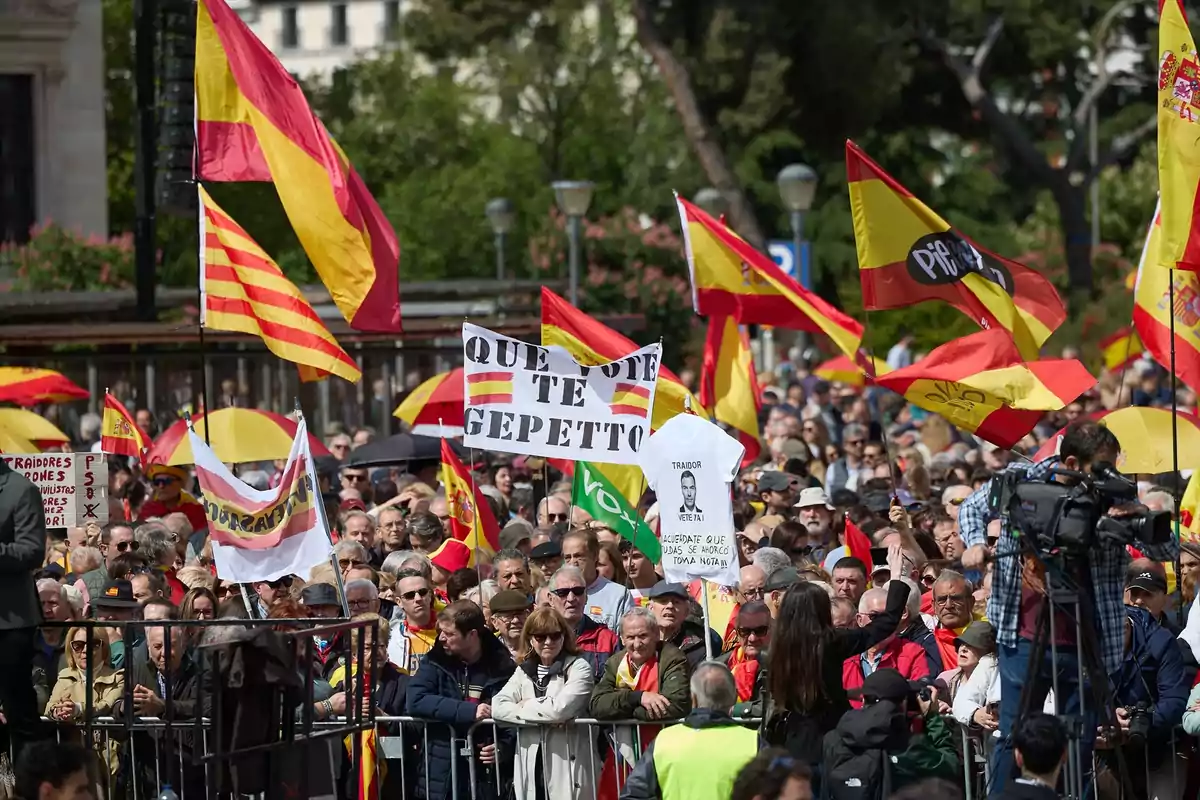 Una multitud de personas se reúne en una manifestación sosteniendo banderas y pancartas en un espacio al aire libre. Una multitud de personas se reúne en una manifestación sosteniendo banderas y pancartas en un espacio al aire libre.