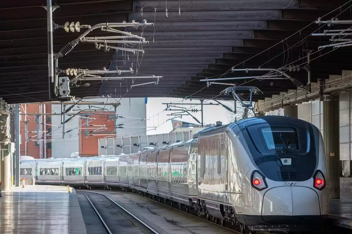 Tren moderno de alta velocidad detenido en una estación cubierta Tren moderno de alta velocidad detenido en una estación cubierta
