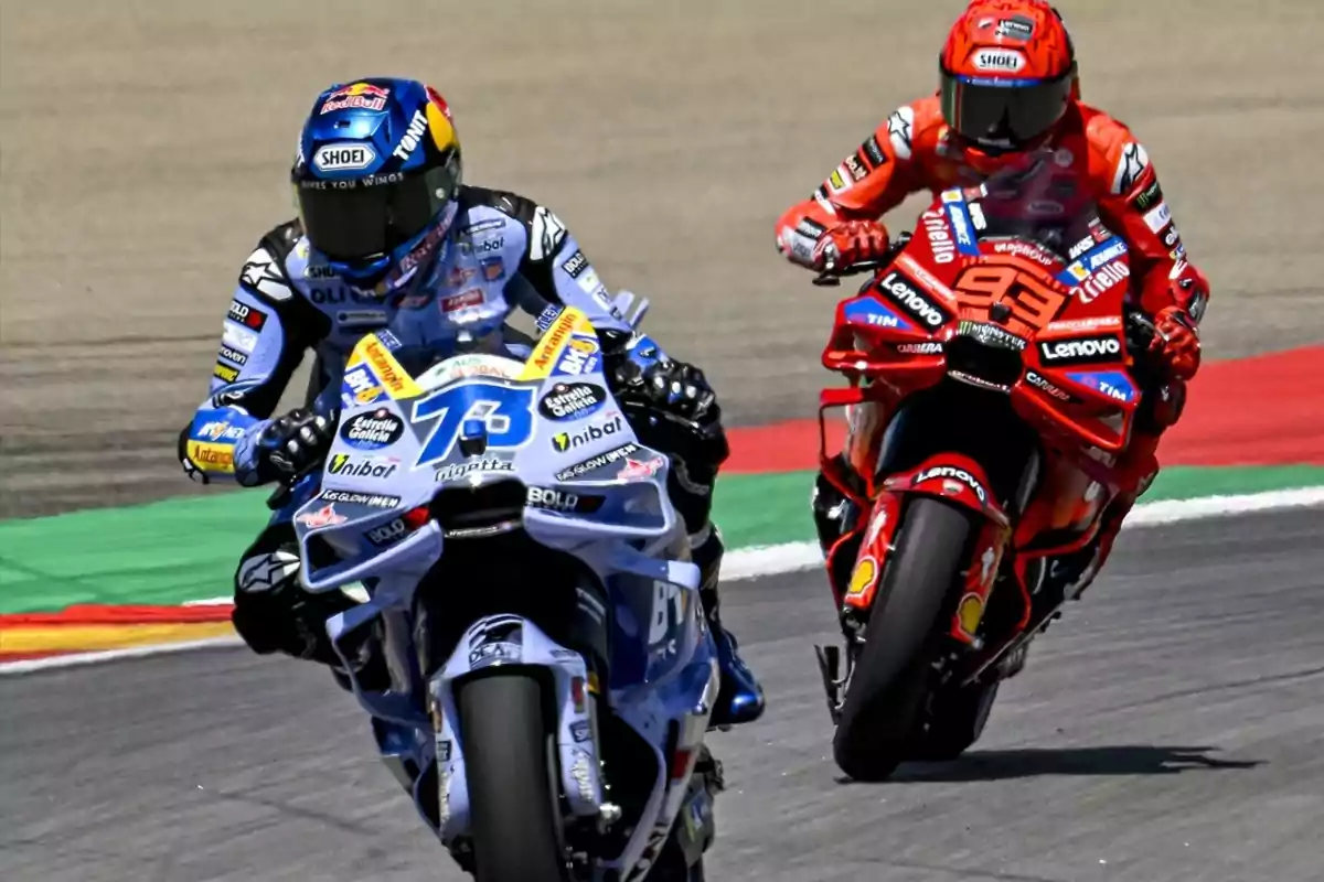 Dos motociclistas compiten en una carrera de motociclismo en una pista asfaltada, uno con moto azul y el otro con moto roja Dos motociclistas compiten en una carrera de motociclismo en una pista asfaltada, uno con moto azul y el otro con moto roja