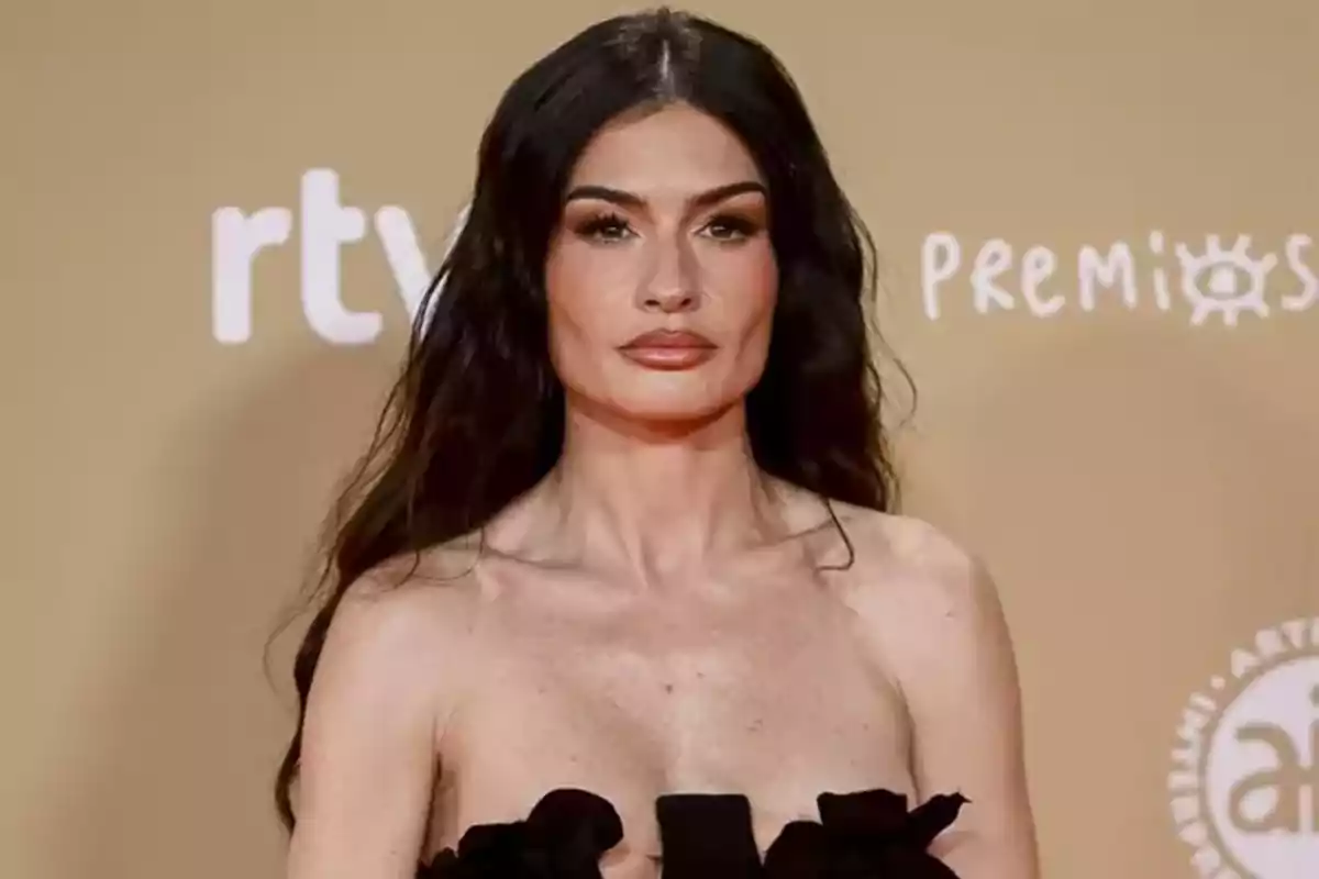 Madame de Rosa con vestido negro en una alfombra roja de premios.