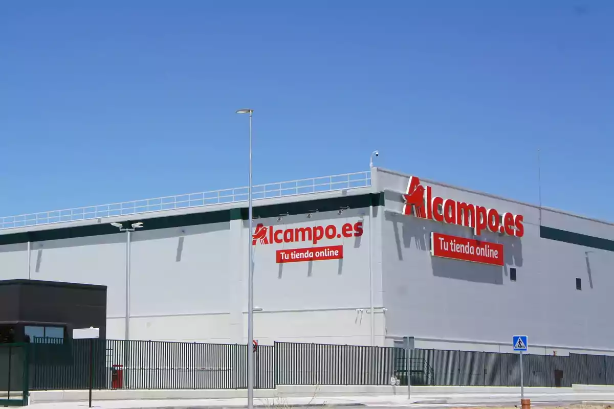 Edificio de Alcampo.es con letreros que dicen "Tu tienda online" en un día soleado.