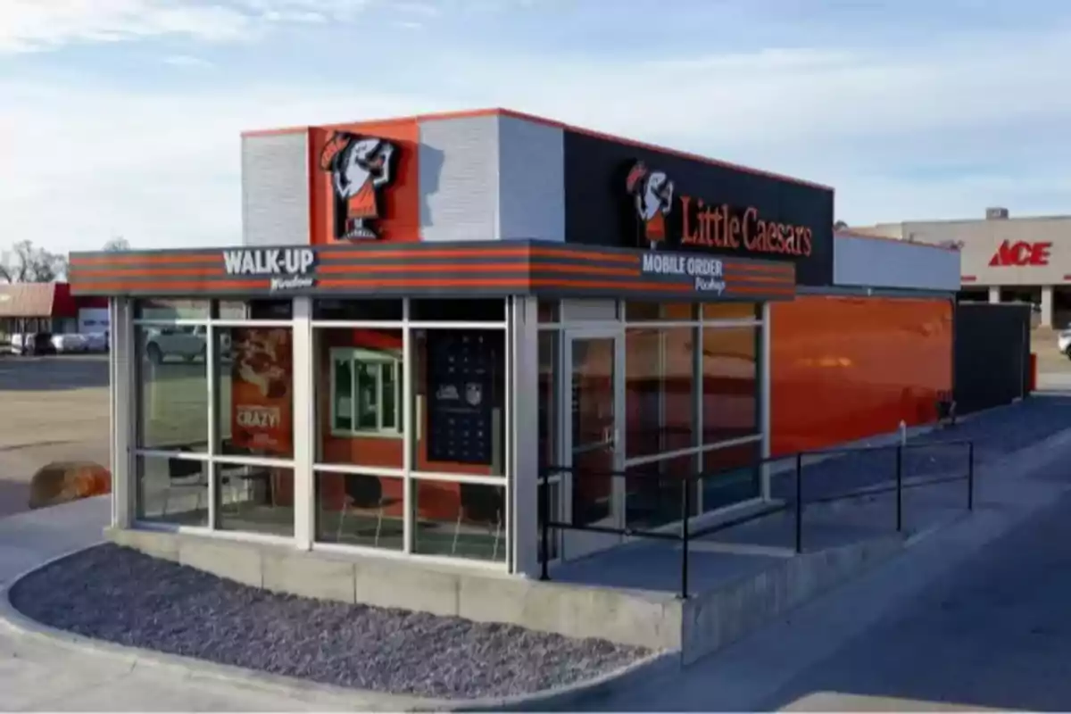 A small Little Caesars branch with a walk-up window for orders and mobile order pickup. A small Little Caesars branch with a walk-up window for orders and mobile order pickup.