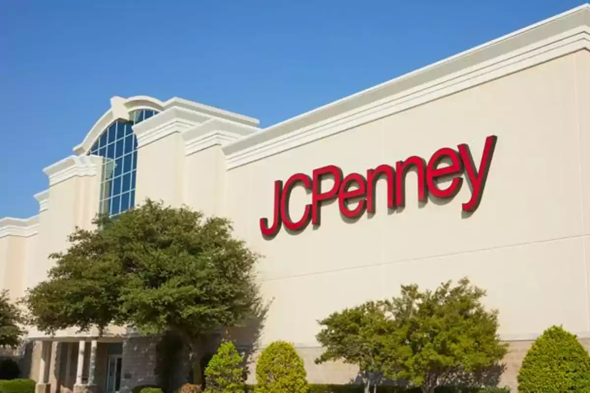 Storefront with the JCPenney logo in red letters and trees in front.