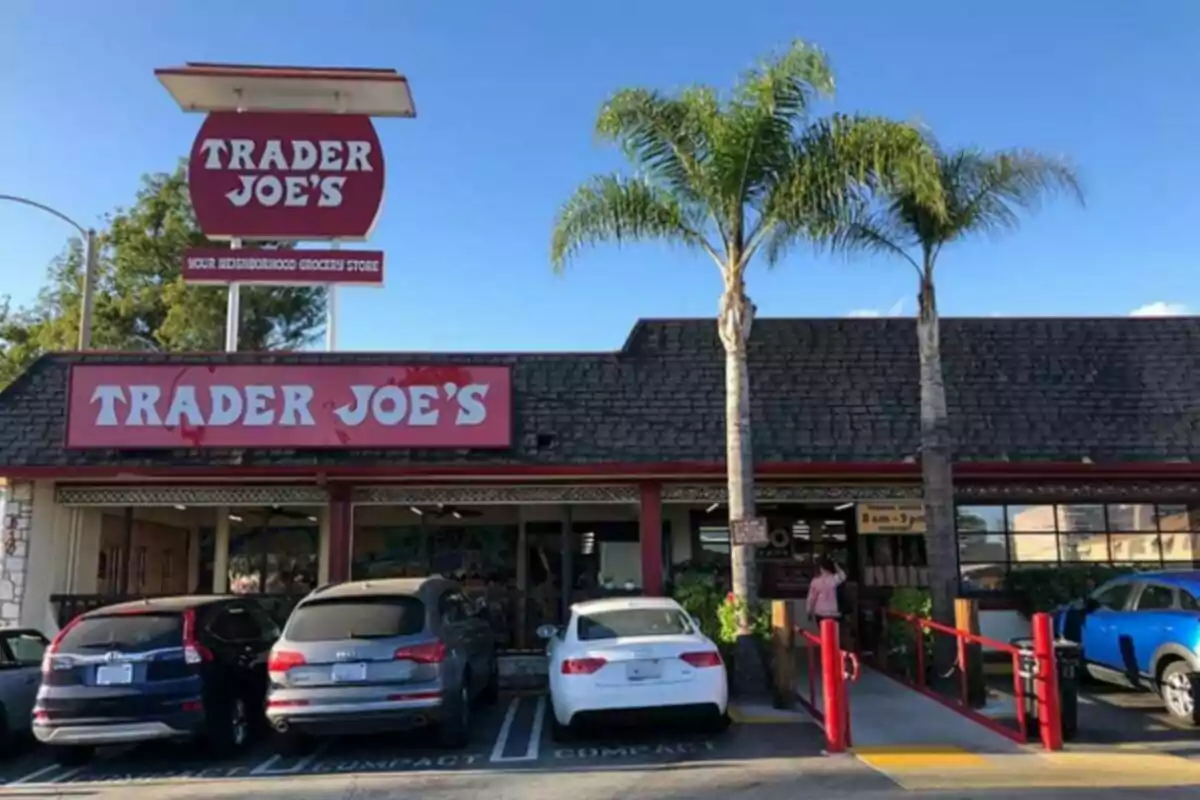 Facade of a Trader Joe's store with cars parked in front and two palm trees next to the entrance Facade of a Trader Joe's store with cars parked in front and two palm trees next to the entrance