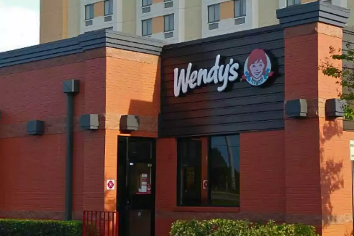 In front of a fast-food restaurant with a sign that says In front of a fast-food restaurant with a sign that says
