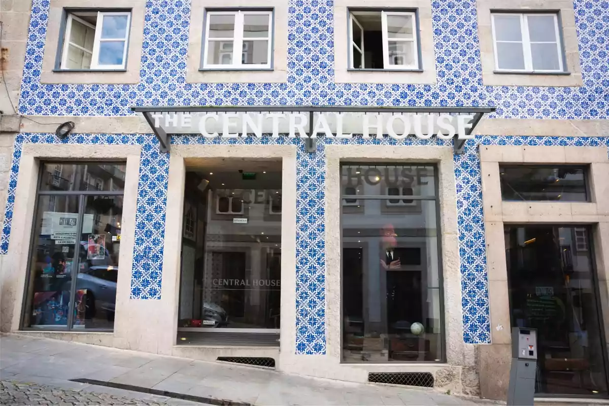 Fachada de un edificio con azulejos azules y blancos y grandes ventanales.