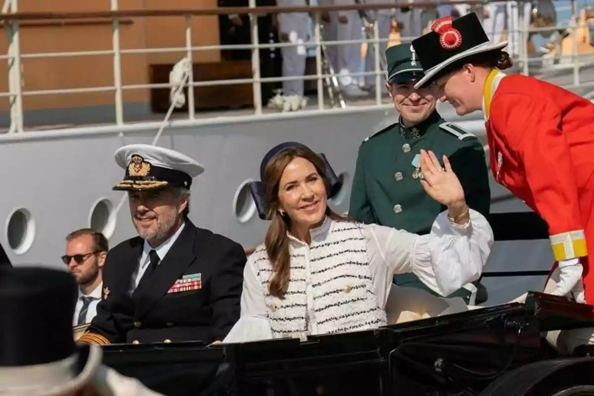 Federico de Dinamarca y Mary Donaldson saludando desde un vehículo en un evento oficial. Federico de Dinamarca y Mary Donaldson saludando desde un vehículo en un evento oficial.