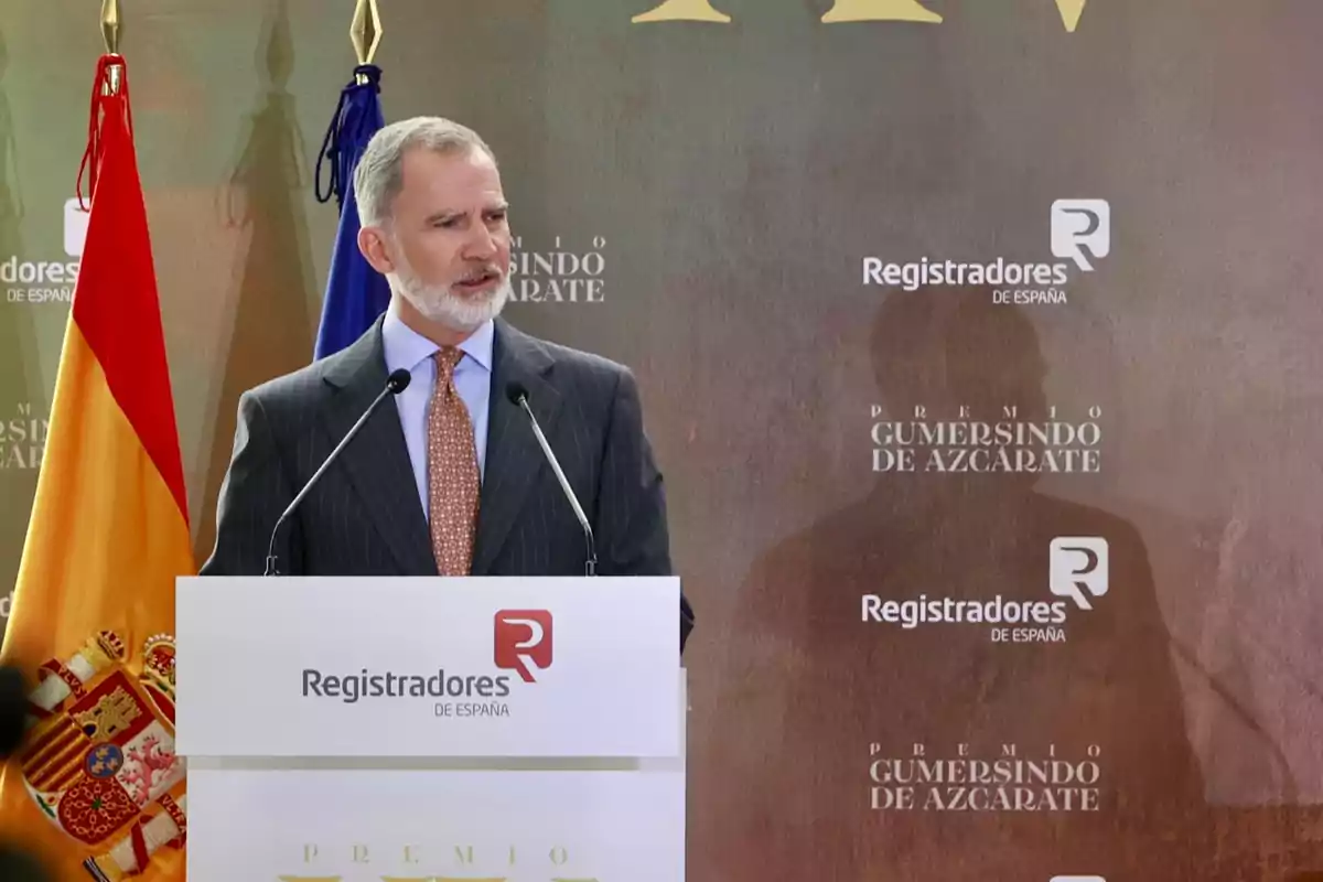 Felipe VI speaking at a podium during an official event with the flags of Spain and the European Union in the background Felipe VI speaking at a podium during an official event with the flags of Spain and the European Union in the background