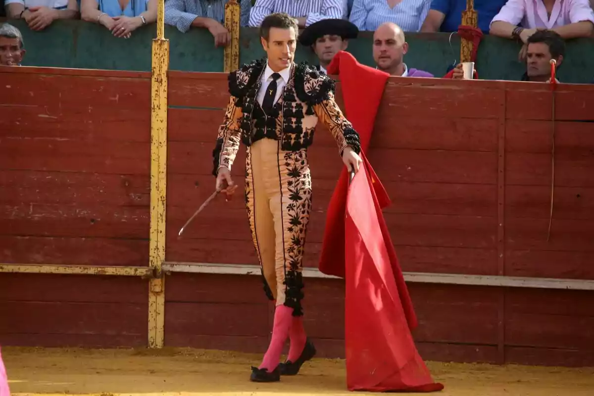 Finito de Córdoba en la plaza de toros sosteniendo una muleta roja mientras el público observa desde las gradas. Finito de Córdoba en la plaza de toros sosteniendo una muleta roja mientras el público observa desde las gradas.