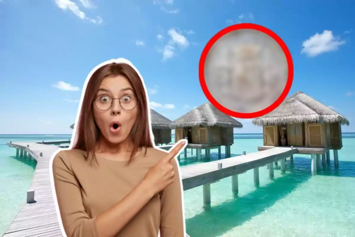 Mujer sorprendida señalando hacia un grupo de bungalows sobre el agua en un entorno tropical.