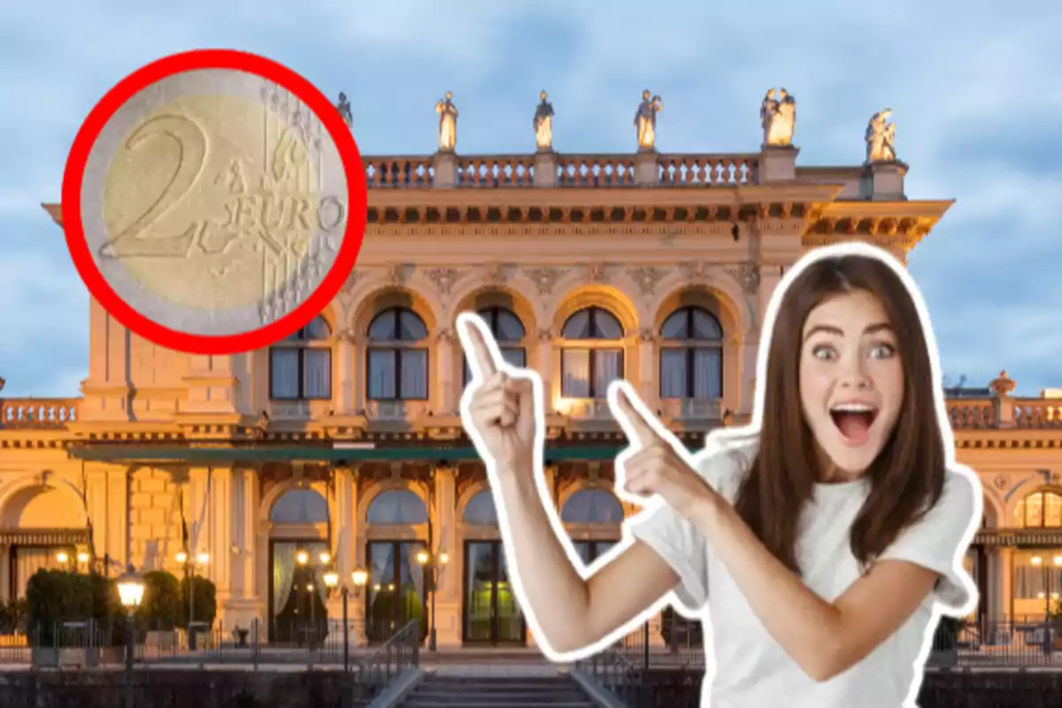 A smiling woman points to a two-euro coin against the backdrop of a lit-up historic building.