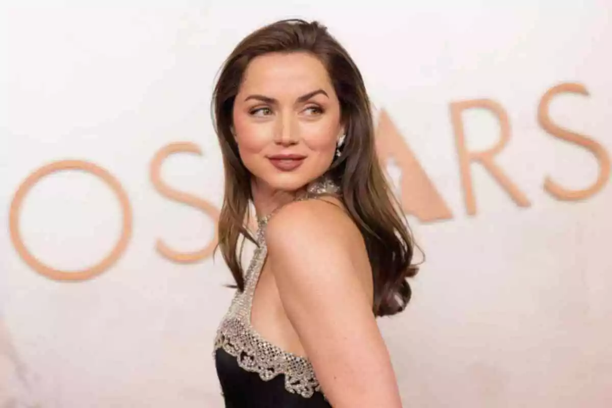 Ana de Armas con un vestido elegante posando en un evento con la palabra Ana de Armas con un vestido elegante posando en un evento con la palabra