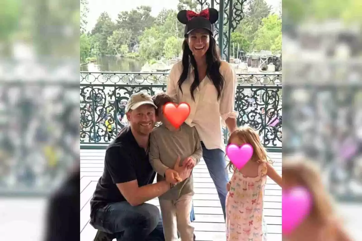 La familia de Meghan Markle y el príncipe Harry sonriente posa en un parque temático de Disney, Meghan lleva una gorra con orejas de ratón y los rostros de los niños están cubiertos con corazones de colores La familia de Meghan Markle y el príncipe Harry sonriente posa en un parque temático de Disney, Meghan lleva una gorra con orejas de ratón y los rostros de los niños están cubiertos con corazones de colores