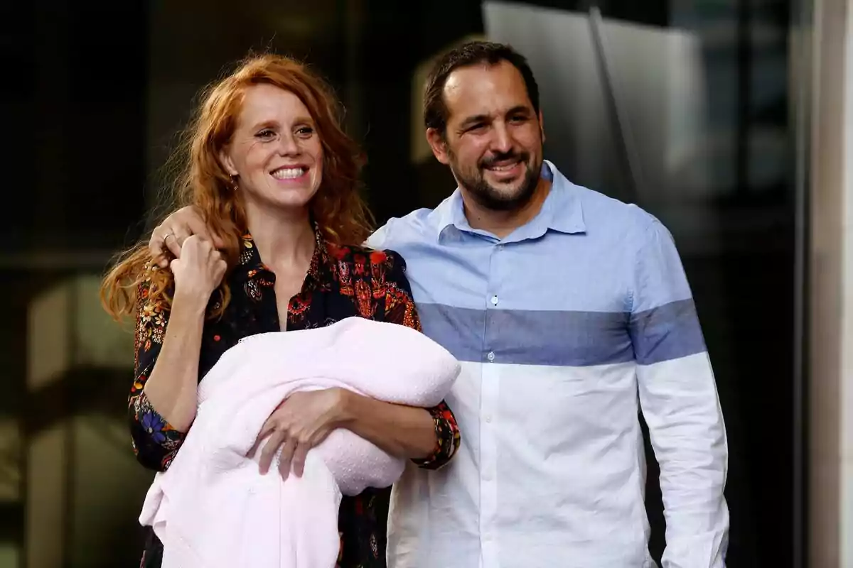 Foto de la actriz María Castro acompañada por su marido, Manuel Villalba, llevando a su hija recién nacida en brazos