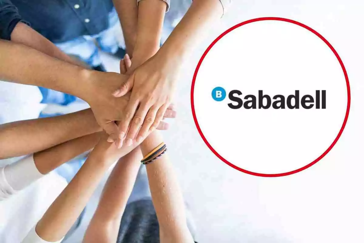 Un grupo de manos unidas en el centro y el logo de Sabadell a la derecha.