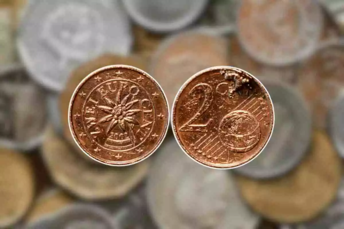Primer plano de dos monedas de 2 céntimos de euro con un fondo desenfocado de otras monedas. Primer plano de dos monedas de 2 céntimos de euro con un fondo desenfocado de otras monedas.