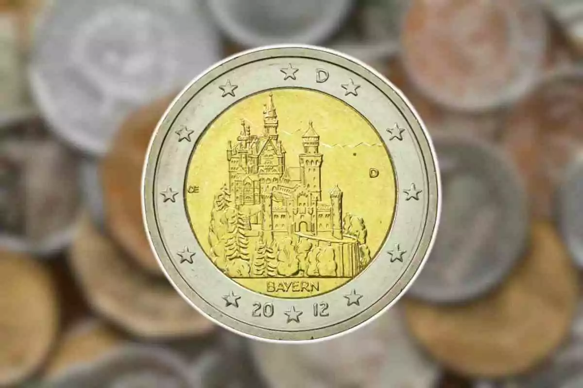 Moneda de dos euros con diseño del castillo de Neuschwanstein en el centro y fondo de otras monedas desenfocadas. Moneda de dos euros con diseño del castillo de Neuschwanstein en el centro y fondo de otras monedas desenfocadas.