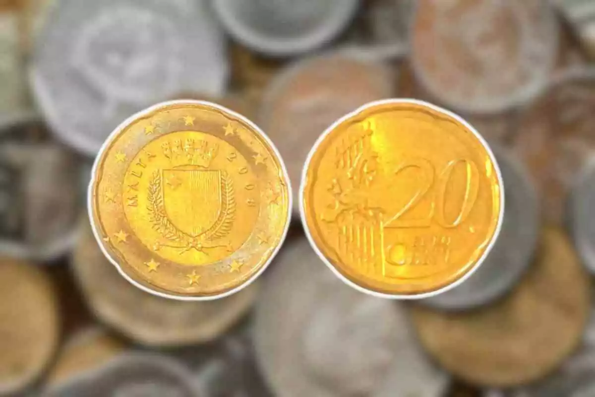Dos monedas de 20 céntimos de euro con un fondo de otras monedas desenfocadas. Dos monedas de 20 céntimos de euro con un fondo de otras monedas desenfocadas.