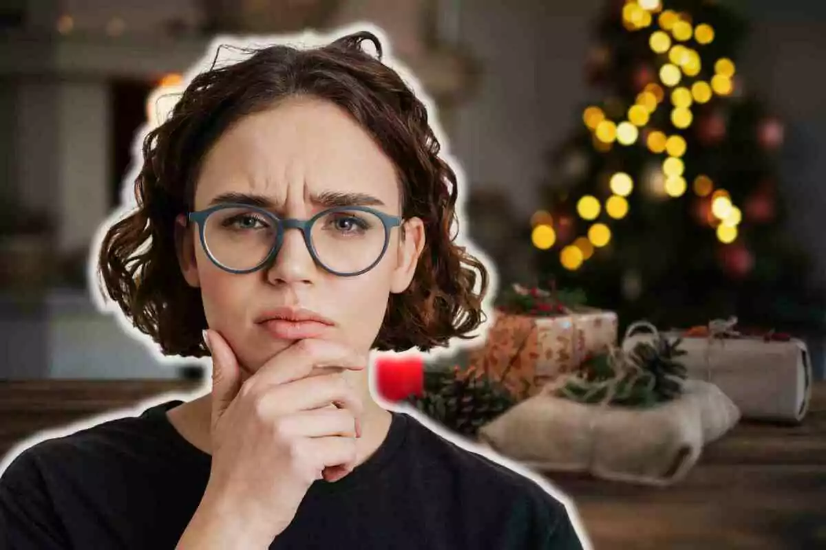 Una persona con gafas y expresión pensativa en primer plano con un árbol de Navidad desenfocado y regalos al fondo.