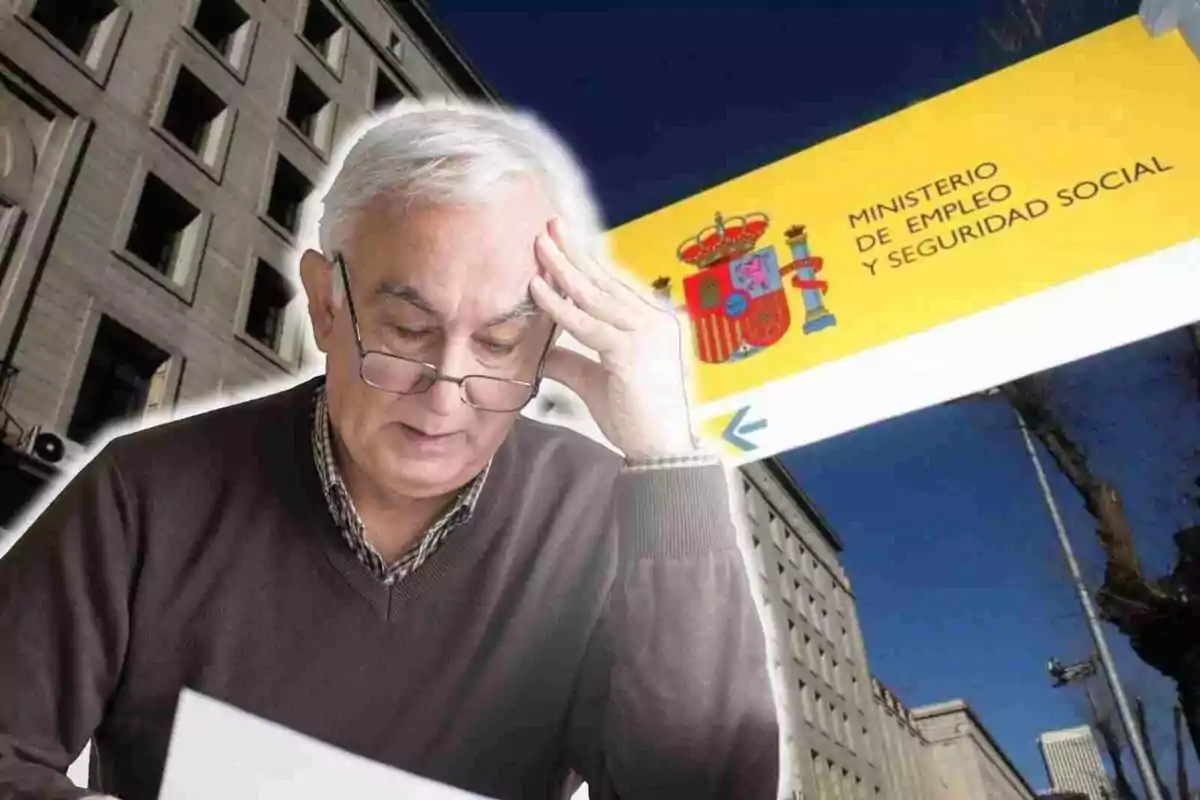 Un hombre mayor con gafas lee un documento mientras se toca la cabeza, con un edificio y un cartel del Ministerio de Empleo y Seguridad Social de España en el fondo.