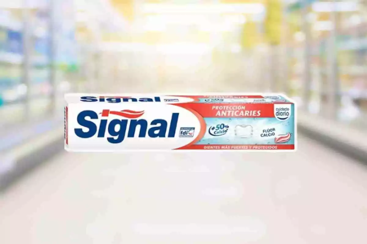 Caja de pasta dental Signal con protección anticaries y fondo desenfocado de supermercado. Caja de pasta dental Signal con protección anticaries y fondo desenfocado de supermercado.
