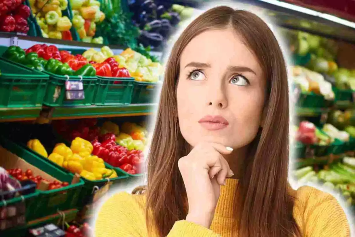 Mujer pensativa frente a estantes de verduras en un supermercado.