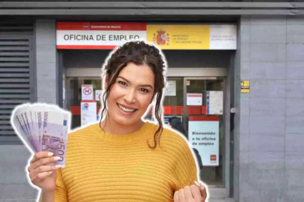 Una mujer sonriente con un suéter amarillo sostiene billetes de 500 euros frente a una oficina de empleo en Madrid.