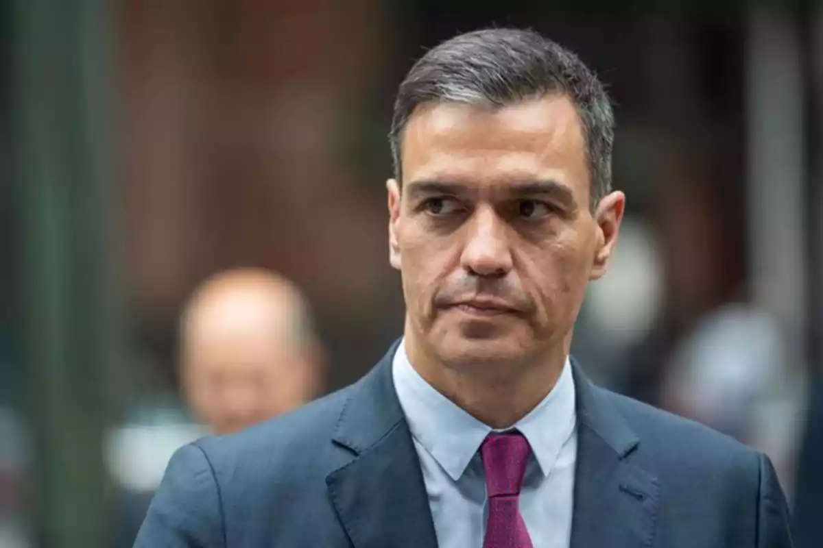 Hombre de cabello corto y canoso con traje azul y corbata rosa en un entorno urbano desenfocado Hombre de cabello corto y canoso con traje azul y corbata rosa en un entorno urbano desenfocado