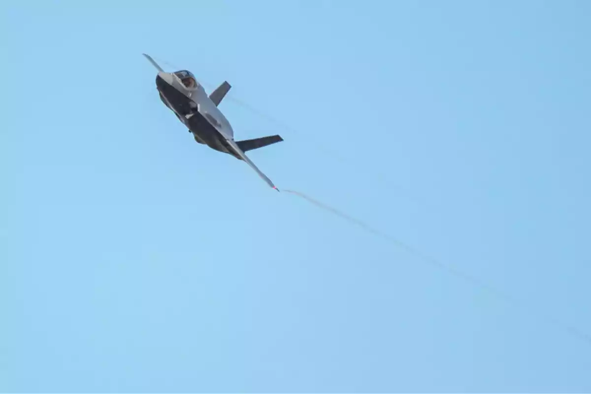 Avión de combate volando en el cielo azul dejando una estela detrás. Avión de combate volando en el cielo azul dejando una estela detrás.