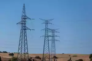 Torres de alta tensión en un paisaje rural con cielo despejado.