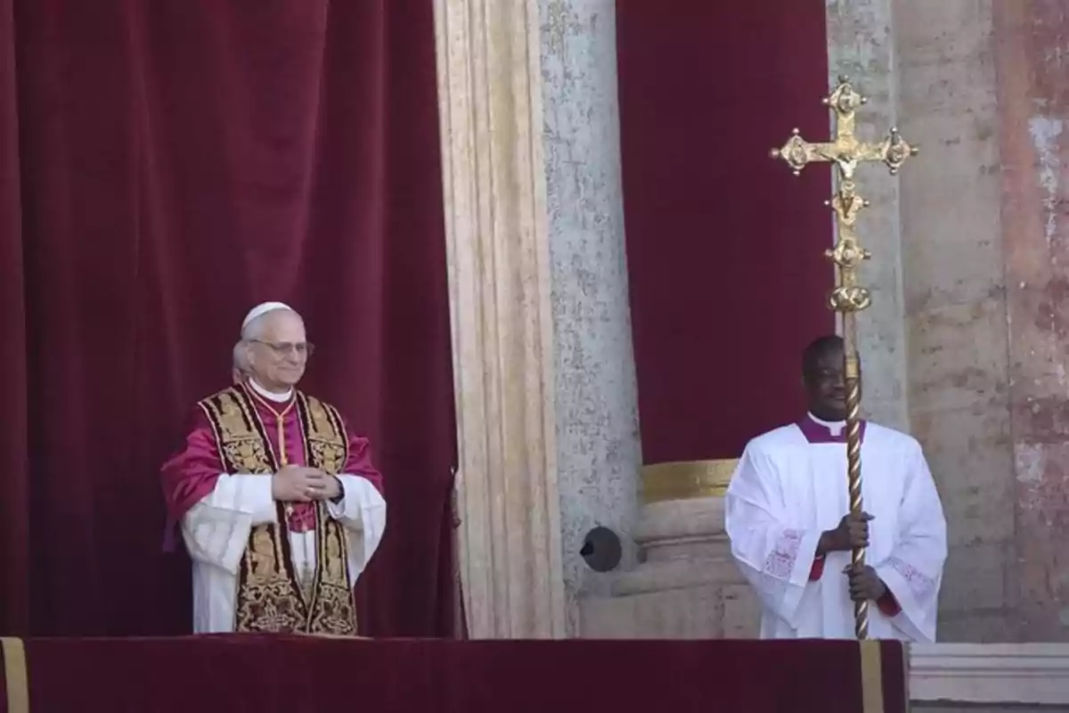 Un clérigo con vestimenta ceremonial y un asistente sosteniendo una cruz dorada en un balcón con cortinas rojas. Un clérigo con vestimenta ceremonial y un asistente sosteniendo una cruz dorada en un balcón con cortinas rojas.