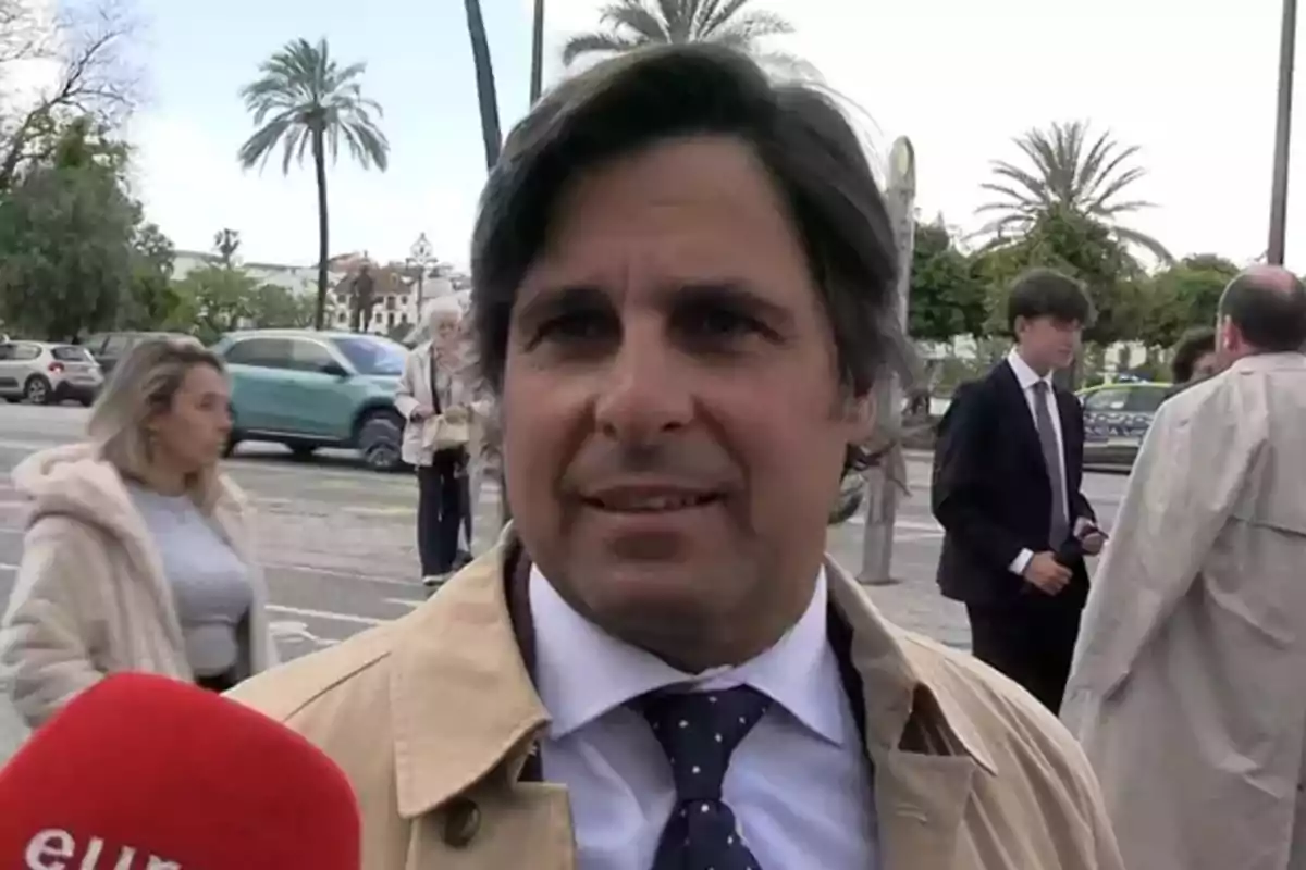 Fran Rivera con chaqueta beige y corbata azul con lunares es entrevistado en la calle mientras personas caminan y autos pasan de fondo. Fran Rivera con chaqueta beige y corbata azul con lunares es entrevistado en la calle mientras personas caminan y autos pasan de fondo.