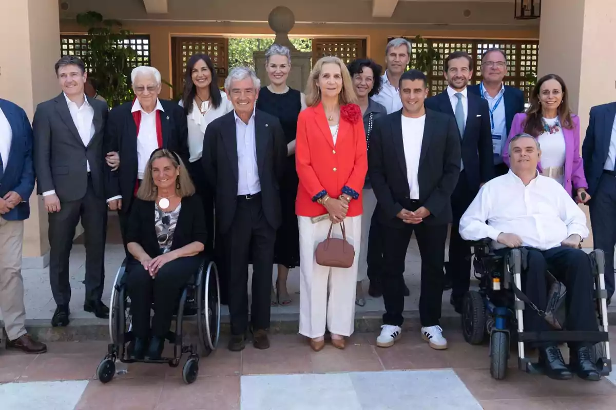 Un grupo de personas posando para una foto en un evento formal, algunas de ellas en silla de ruedas, todos sonrientes y bien vestidos