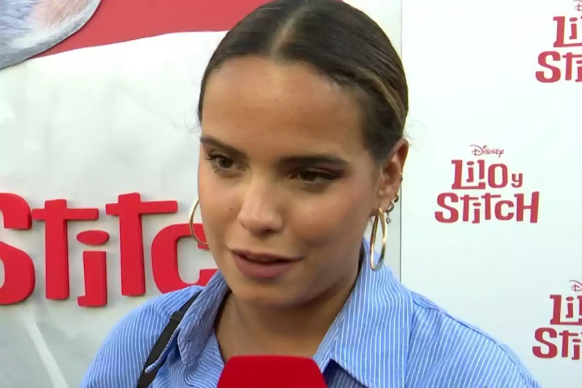 Gloria Camila con camisa azul y micrófono rojo en un evento de Gloria Camila con camisa azul y micrófono rojo en un evento de