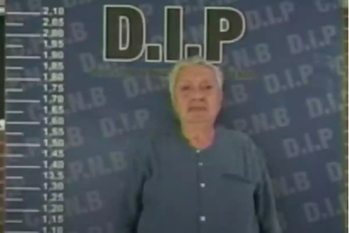 Persona mayor frente a un fondo con las letras "D.I.P" y una escala de altura a la izquierda.