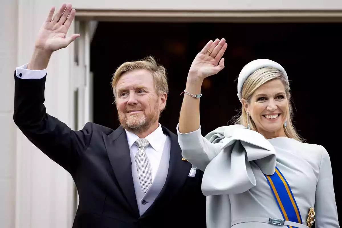Guillermo and Máxima of the Netherlands, elegantly dressed, wave and smile from a balcony. Guillermo and Máxima of the Netherlands, elegantly dressed, wave and smile from a balcony.