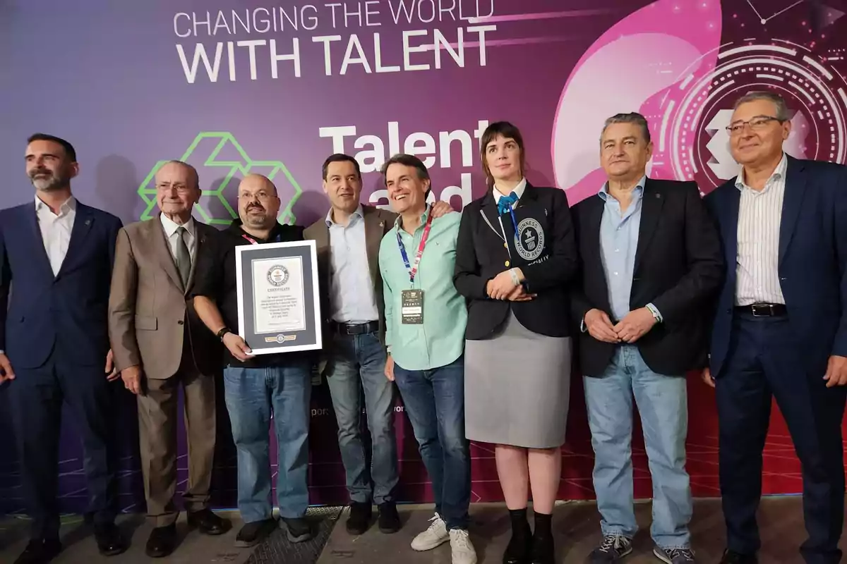 Un grupo de personas posando para una foto, una de ellas sostiene un certificado de récord mundial de Guinness, con un fondo que dice "Changing the World with Talent".